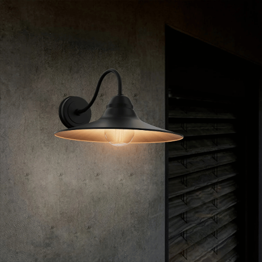 Gooseneck industrial wall light with metal shade and warm exposed bulb.