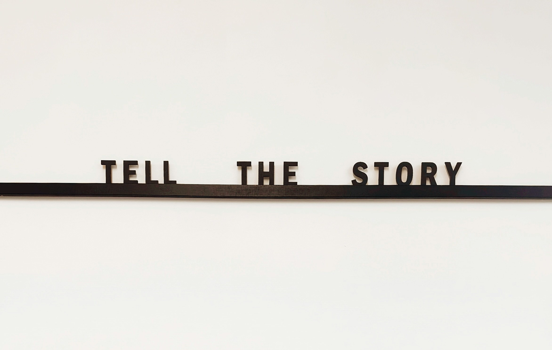 A wooden sign that says 'tell the story'.