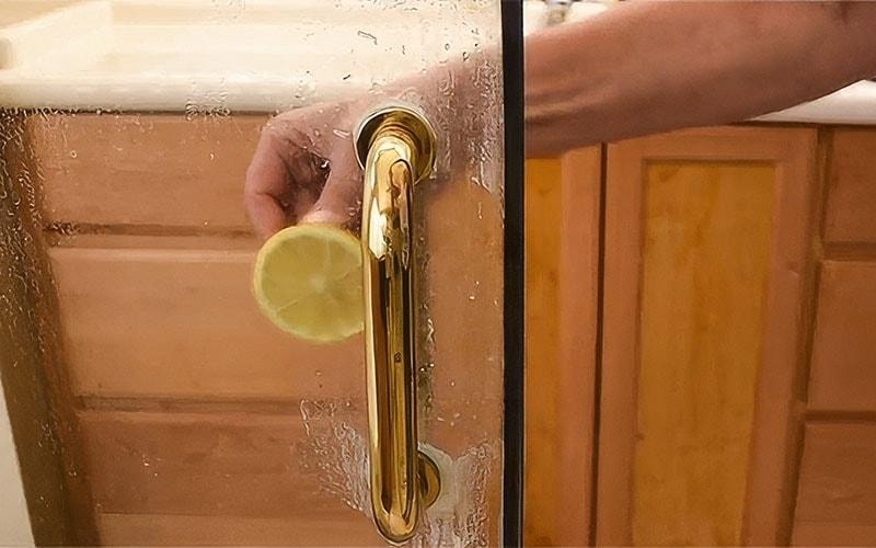 Cleaning glass shower door with lemon slice