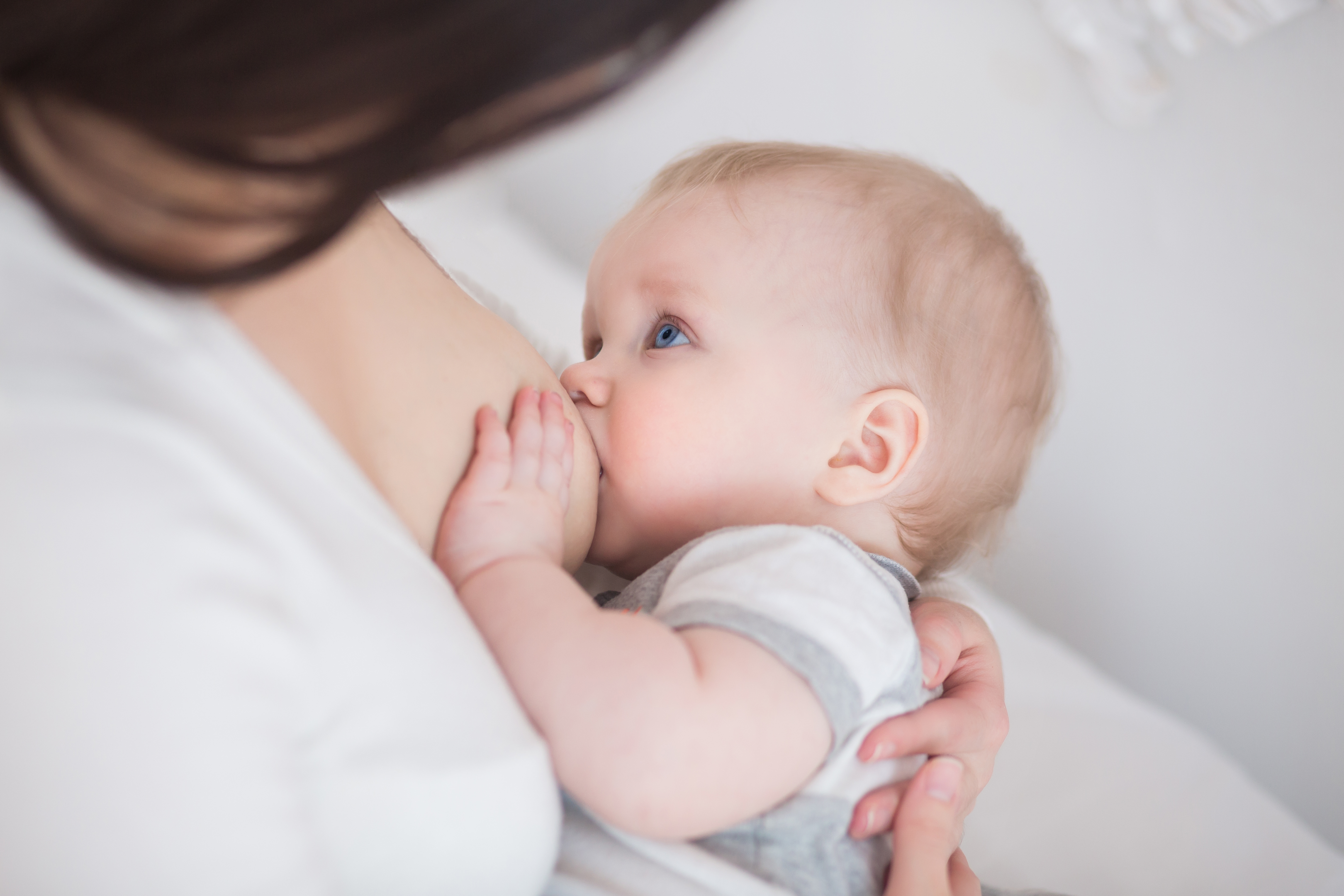 Baby with blue eyes breastfeeding