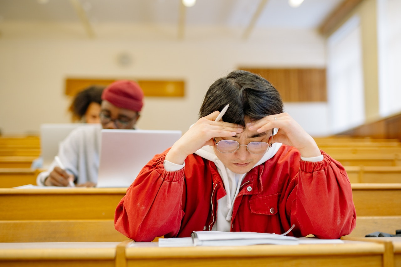 https://www.pexels.com/photo/man-in-red-jacket-studying-at-a-classroom-8197500/