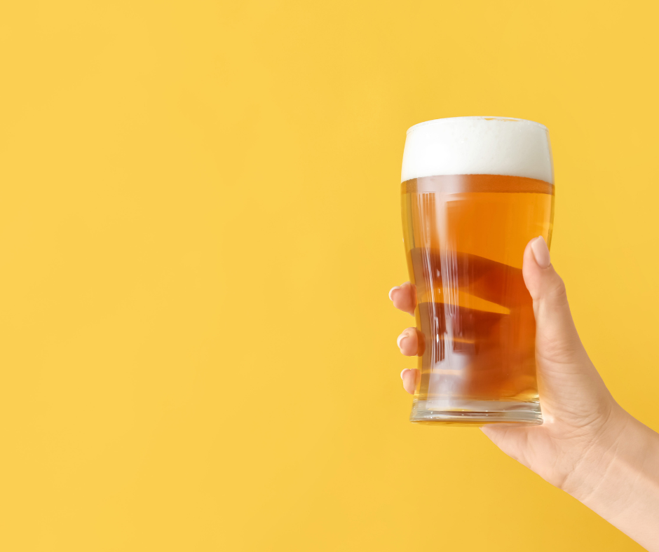A person holding a pint glass and looking away from the camera, symbolizing the journey of quitting alcohol
