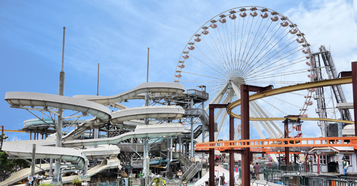 Wildwood Boardwalk amusement rides including a Ferris wheel and water slides near North Wildwood rentals.