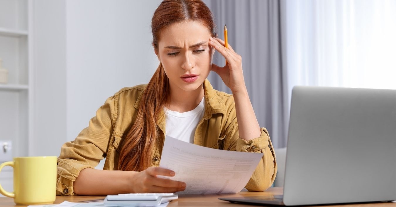 OnlyFans creator reviewing prorated taxes and financial documents with a laptop and calculator.