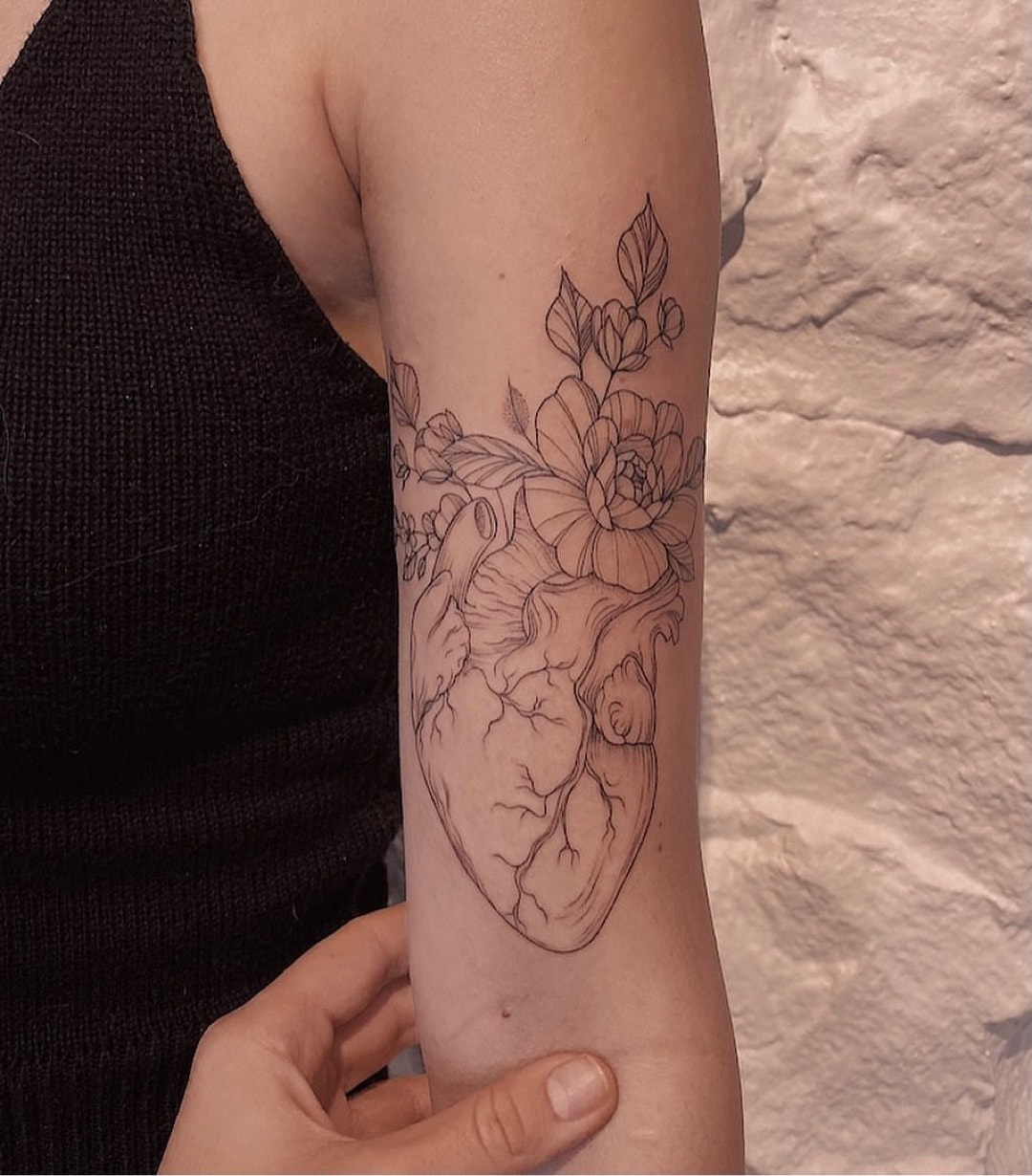 Blumen Tattoo mit einem Herz auf dem Arm