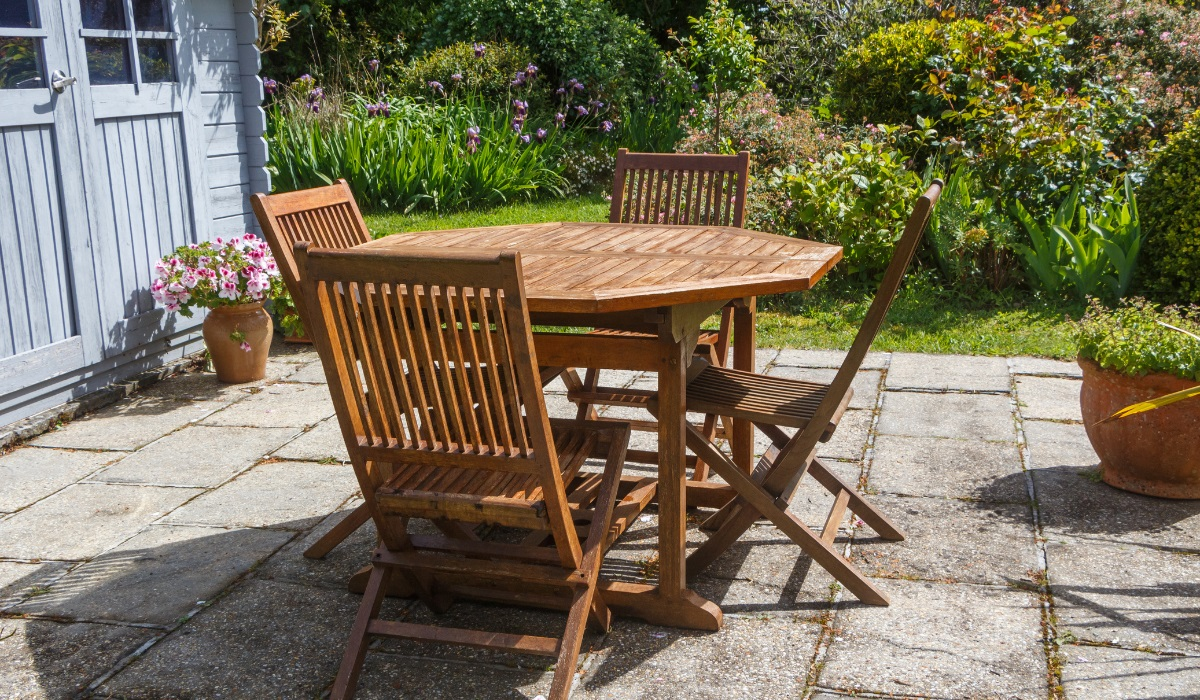 Restoring wooden garden furniture - table and four chairs on a patio
