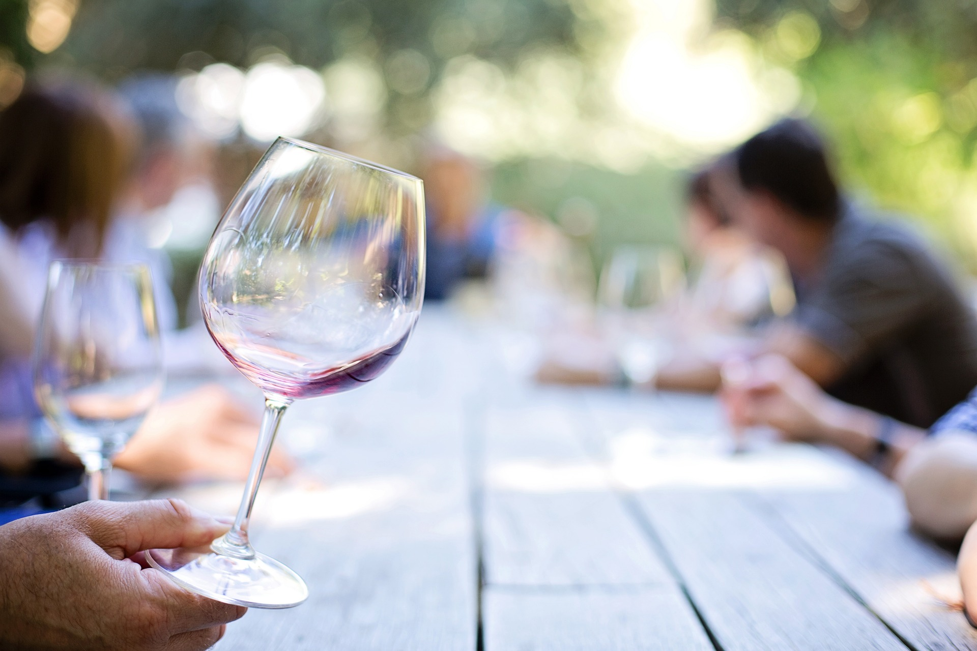 Hand holding a wine glass by the base