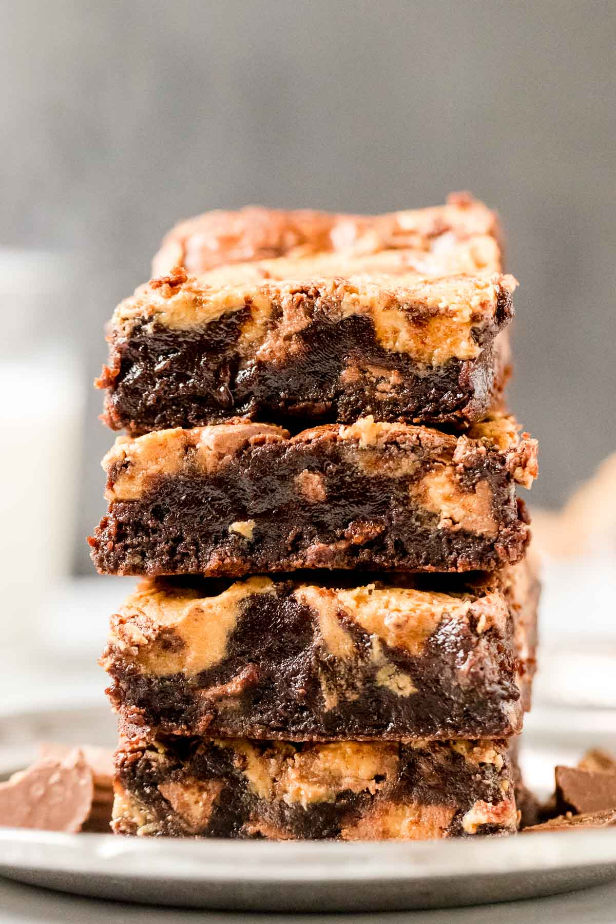 four peanut butter brownies stacked on a plate