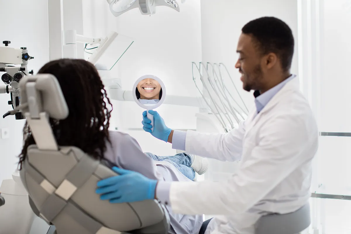 Dentist showing patient their smile in mirror during consultation