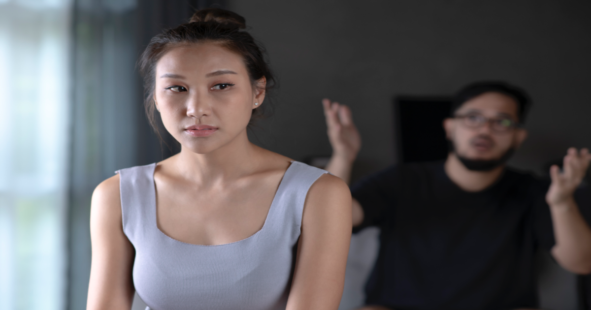 A photograph of a couple standing face-to-face with their arms crossed and tense expressions on their faces. The image conveys the idea of a couple experiencing conflicts or difficulties in their relationship, possibly related to communication or emotional connection. It suggests that seeking the services of a certified Gottman Method Couples Therapist in New York City can provide the couple with the tools and techniques needed to improve their communication, build emotional connection, and reduce conflict in their relationship.