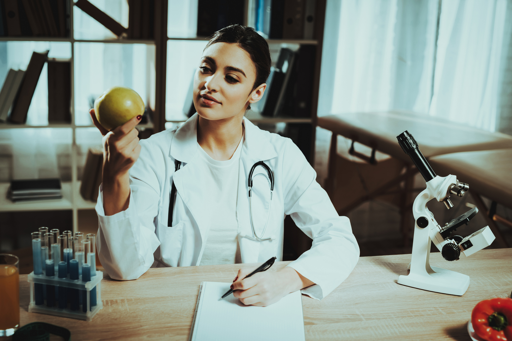 Female doctor reasearches apple for nutritional psychiatry. Image credit Oleh Veres