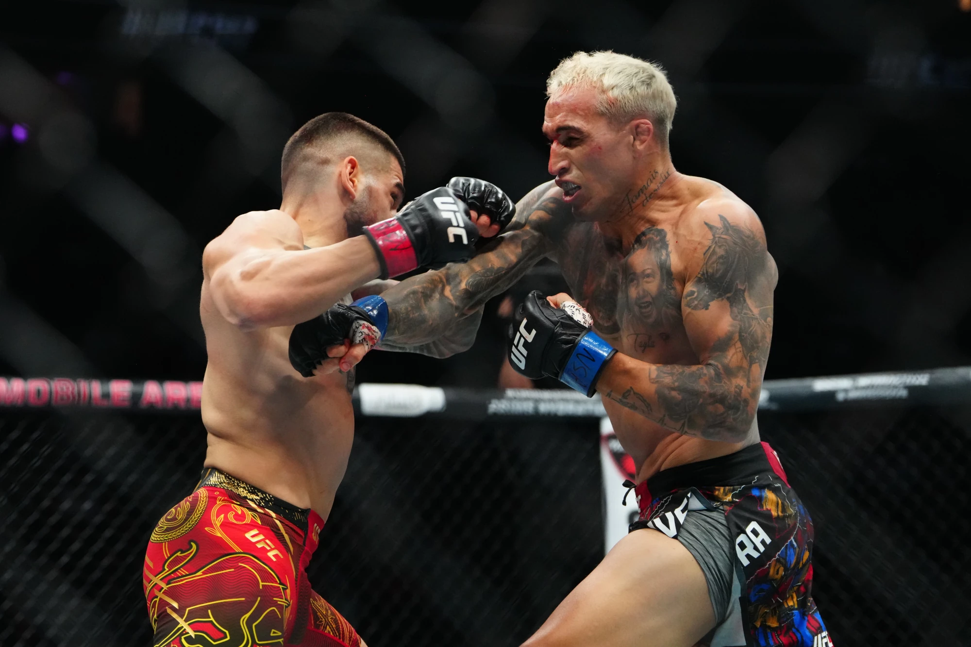 Jun 28, 2025; Las Vegas, Nevada, USA; Ilia Topuria (red gloves) fights Charles Oliveira (blue gloves) during UFC 317 at T-Mobile Arena. 
