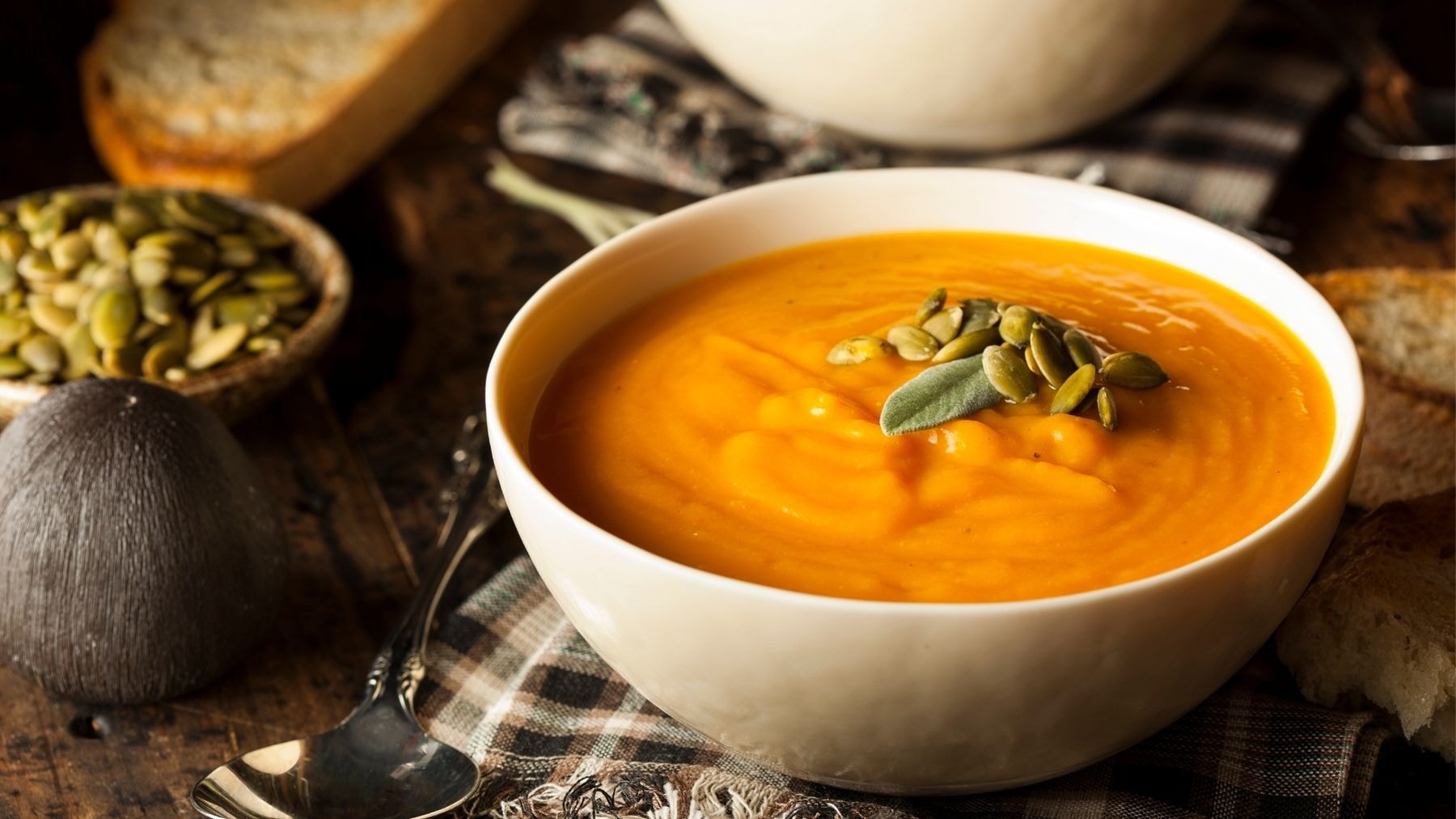 A bowl of creamy butternut squash soup garnished with pumpkin seeds
