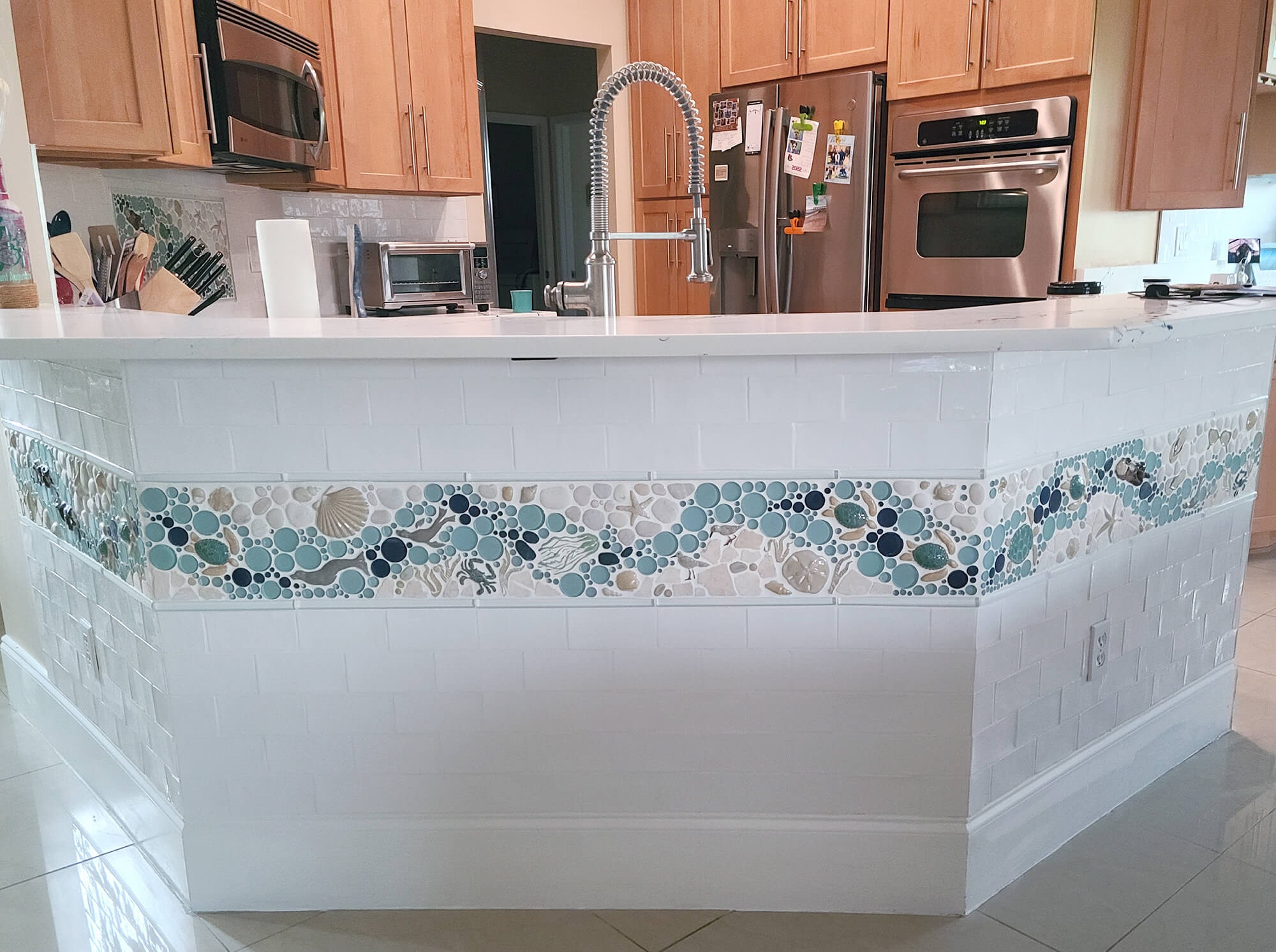 even the island can be tied into the kitchen decor by continuing the mosaic from the backsplash onto its border