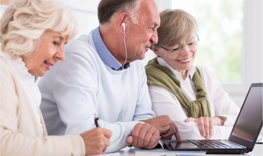 Seniorzy przeglądają na komputerze ranking najtrudniejszych języków świata i poznają ich podstawy.