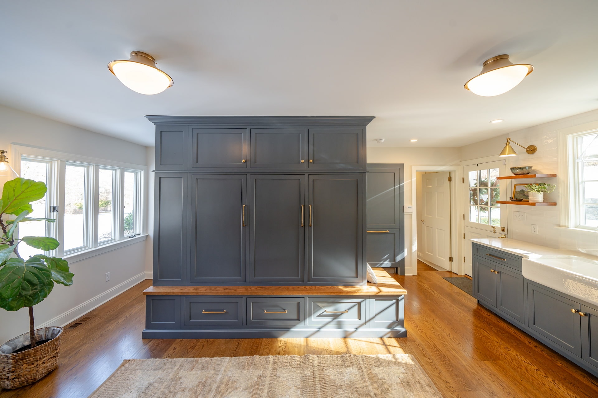 Photo of slate blue kitchen cabinets with a built-in bench that has drawers beneath it