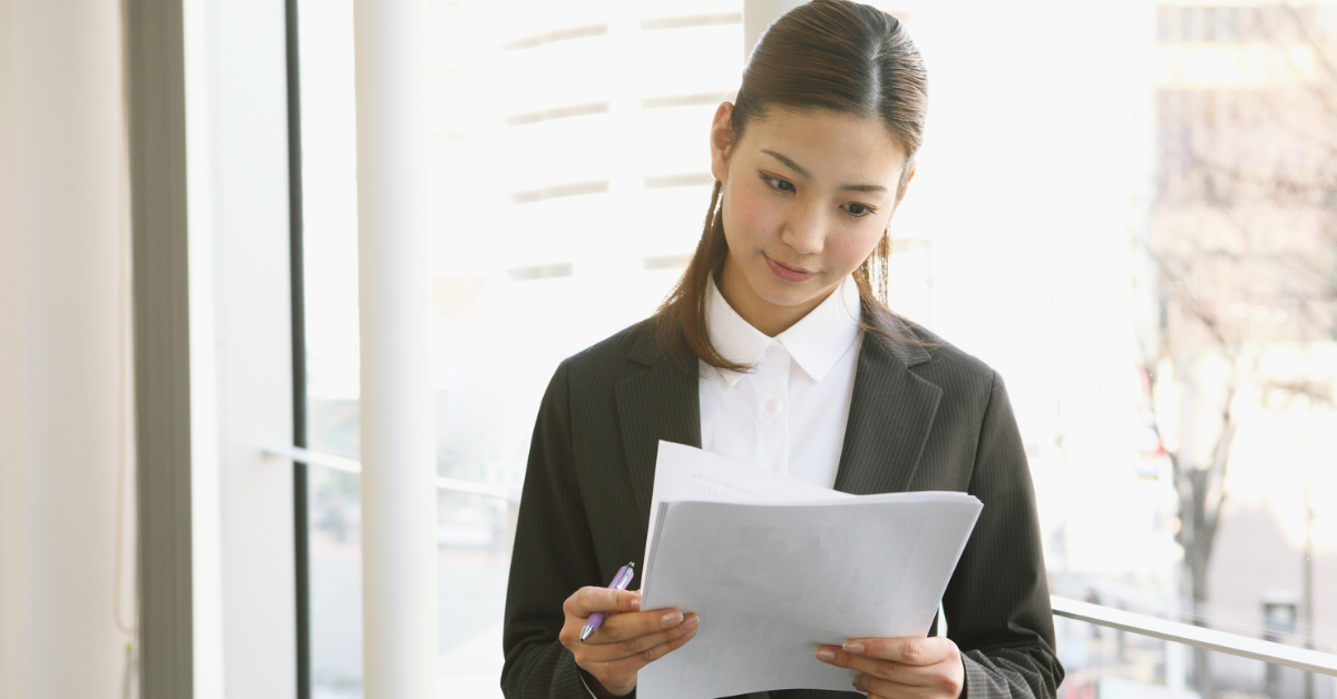 A woman managing financial planning for small business owners, reviewing documents.