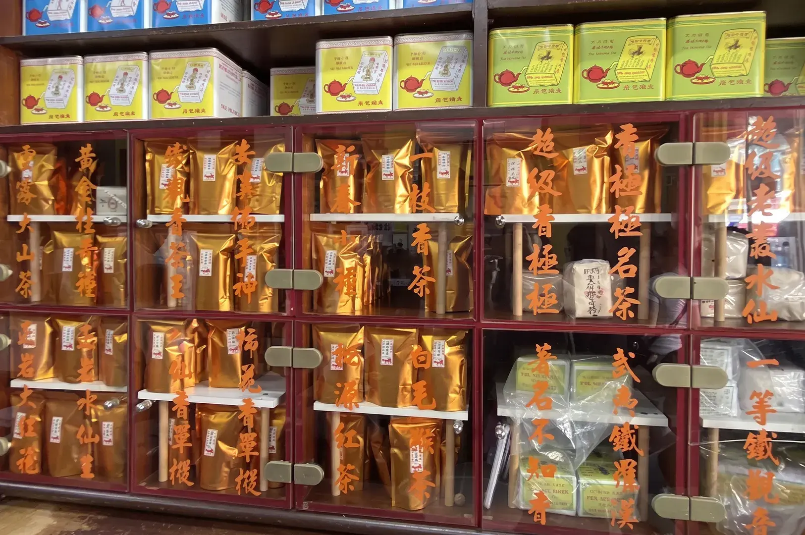 Traditional Chinese tea shop cabinets filled with gold foil tea bags and tins.