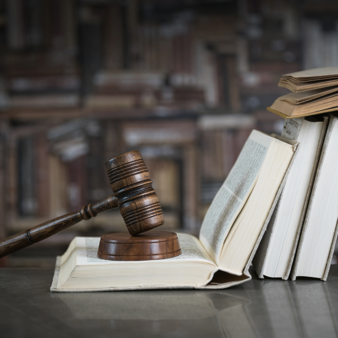 Gavel on an open book surrounded by other books