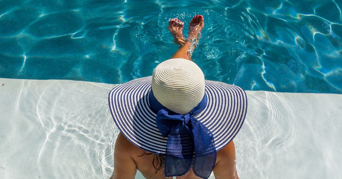 Guest relaxing at Gardens Plaza Ocean City pool with sun hat, enjoying the coastal luxury lifestyle and resort-style amenities.