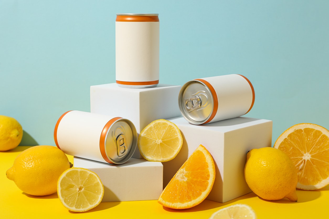 flavor innovation flat lay: citrus, berry, botanicals with color‑matched cans, minimal premium composition
