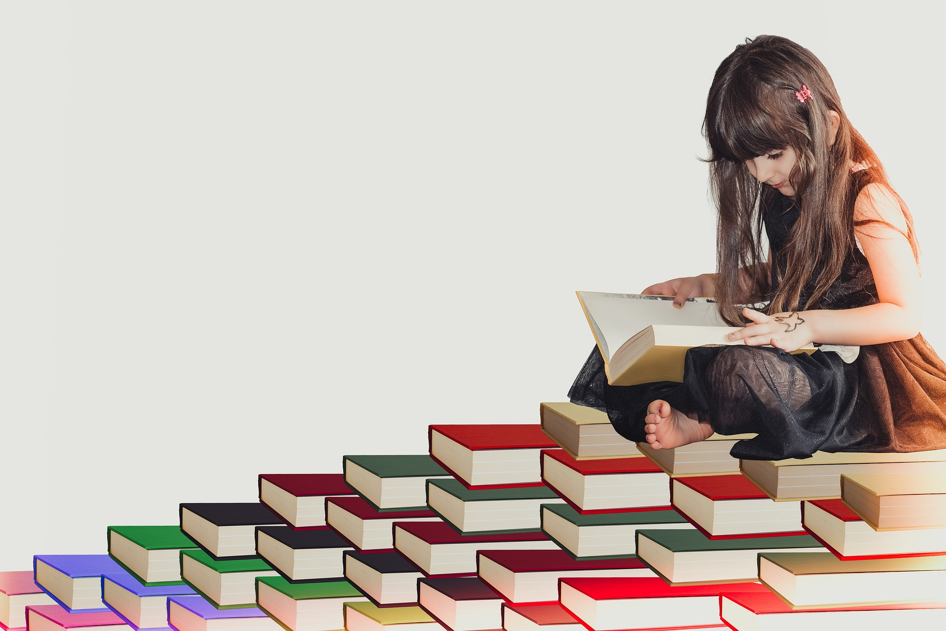A child reading on a pile of books
