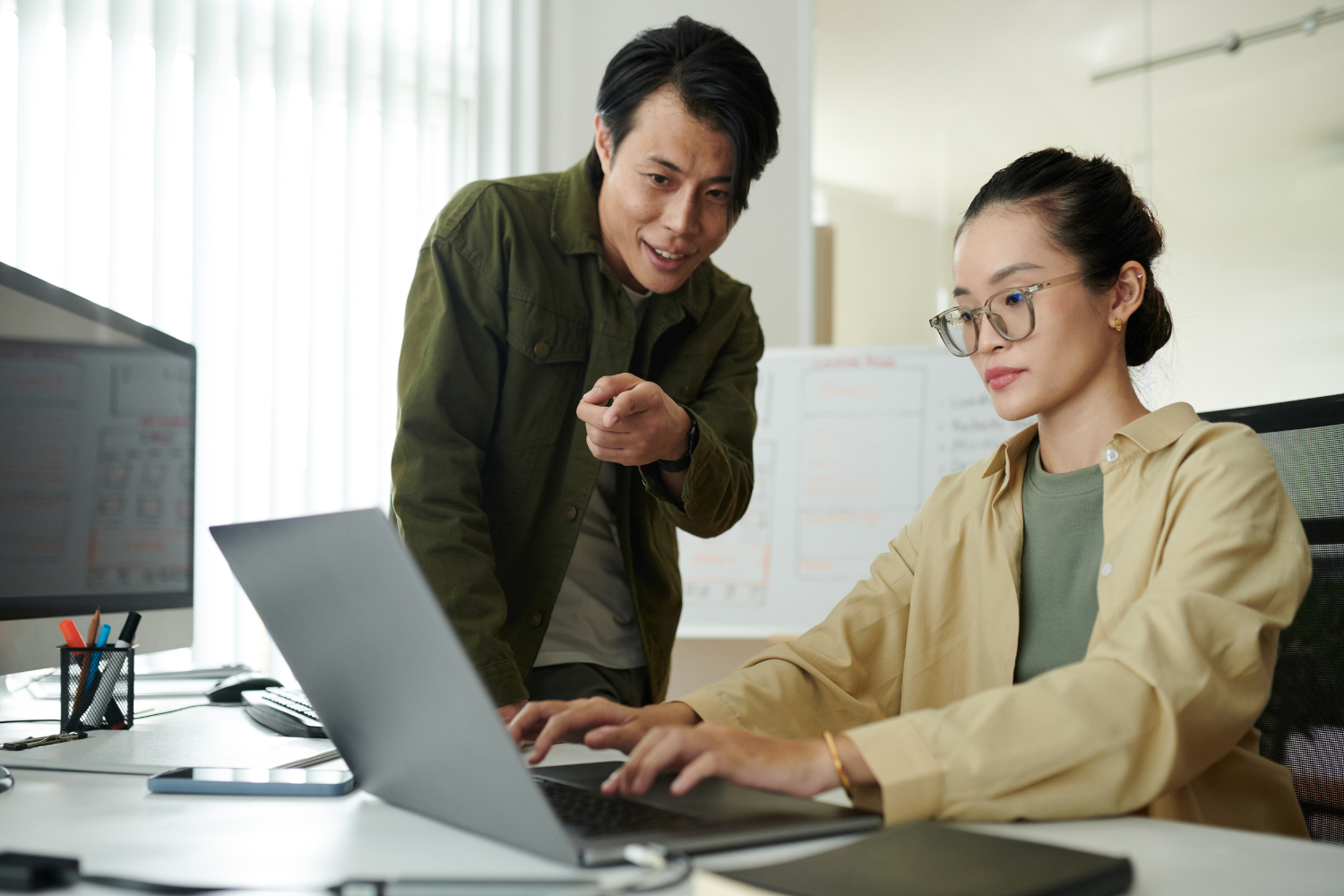 A team leader talking supportively to a Filipino teammate.