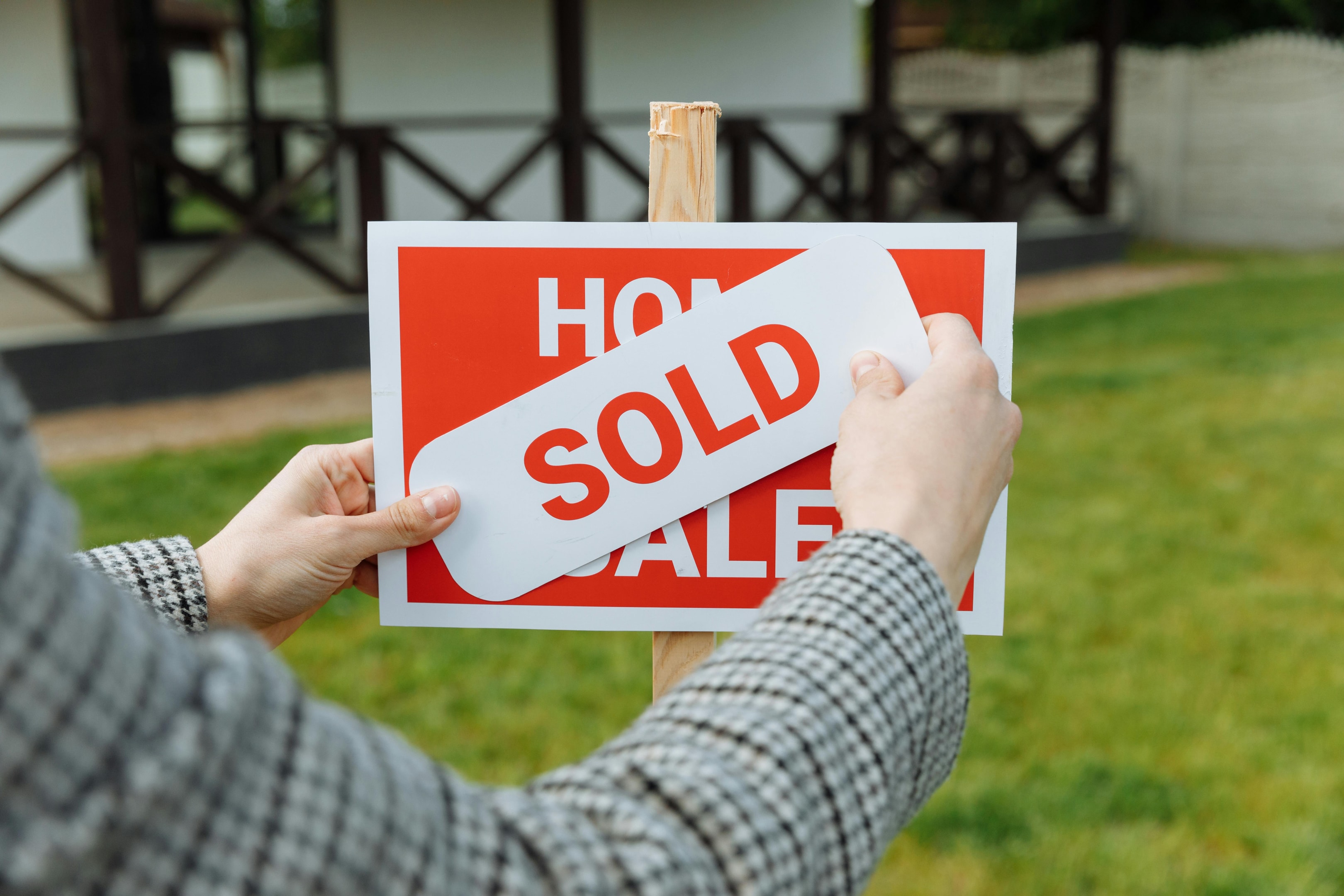 Home sold sign in front of house. 