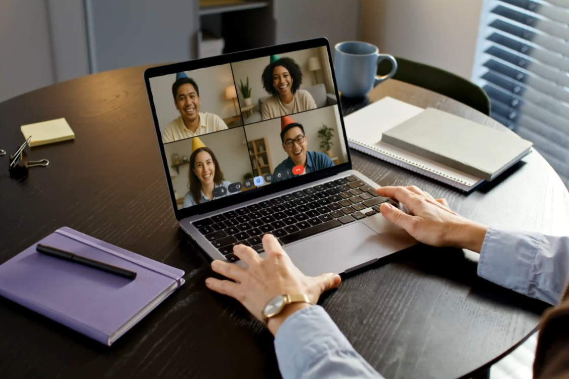 Remote team having a virtual celebration during a video call, showing workplace bonding and positive team culture