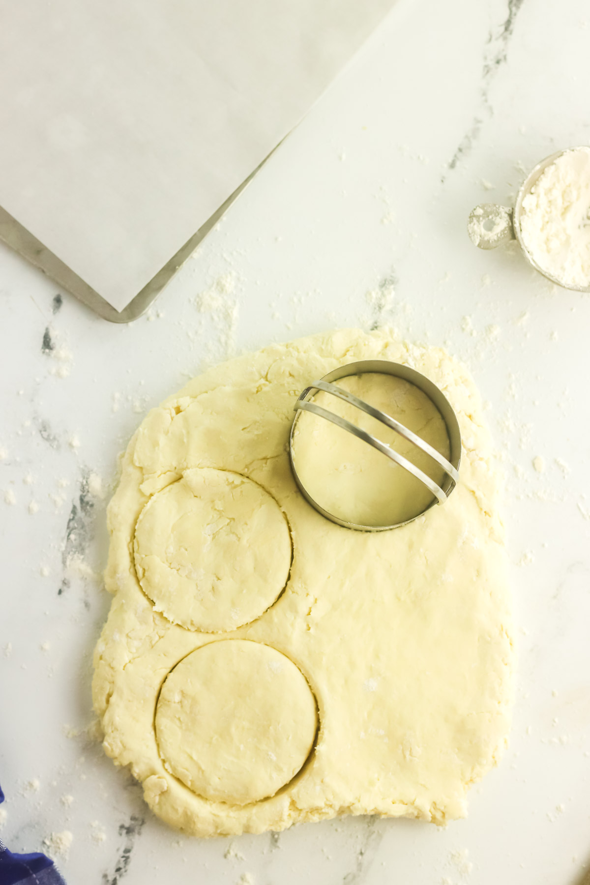 biscuit dough being cut out with a biscuit cutter