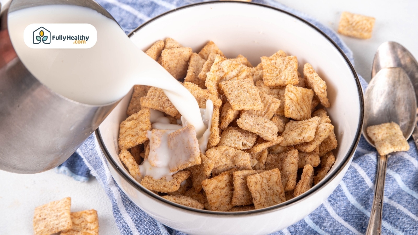 Colorful cereal loops with milk in spoon over blue bowl