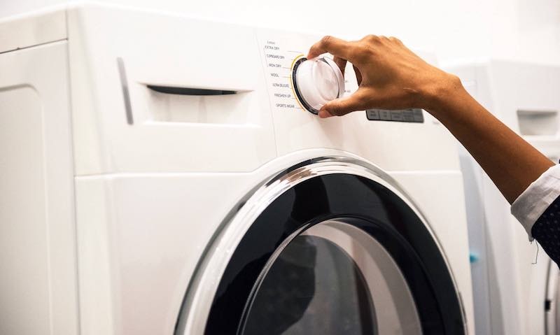 A washing machine filled with fresh laundry ready to be washed with homemade detergent.