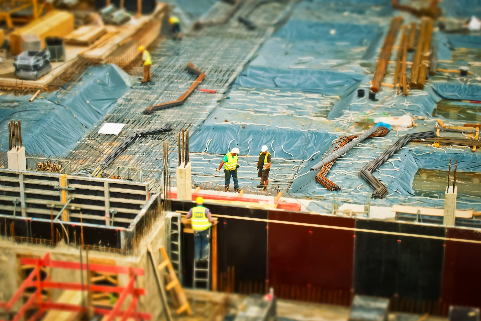 Construction workers in hard hats and safety vests working on a building in a city