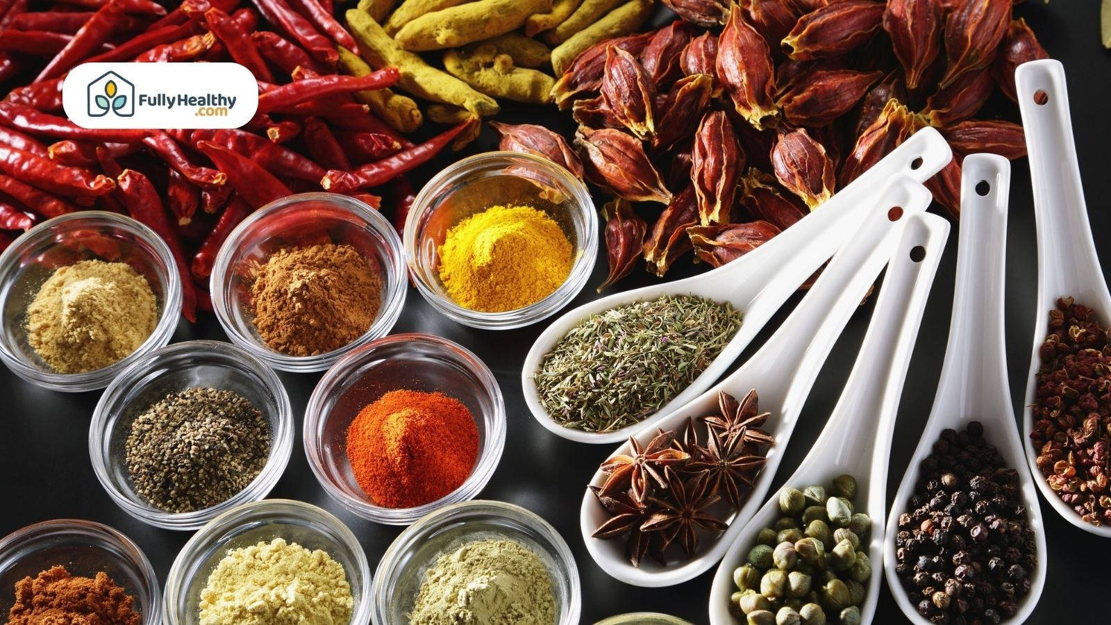 Assorted spices and herbs in glass bowls and ceramic spoons