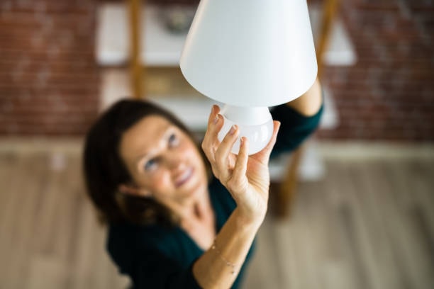 A women installing an energy-efficient LED bulb.