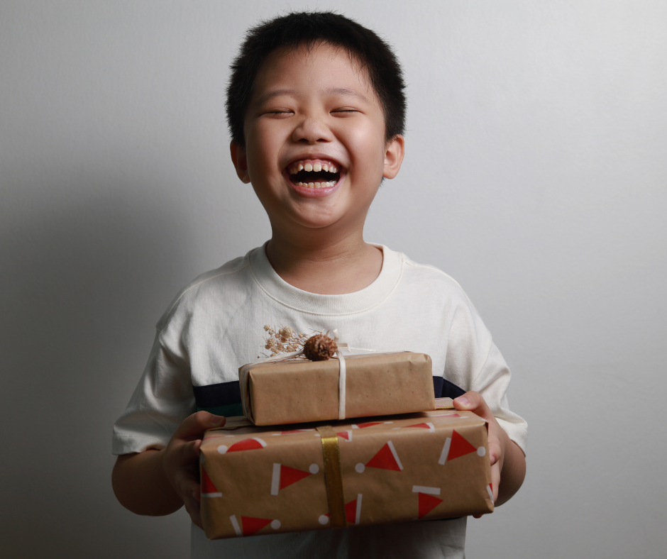 a happy child holds two presents