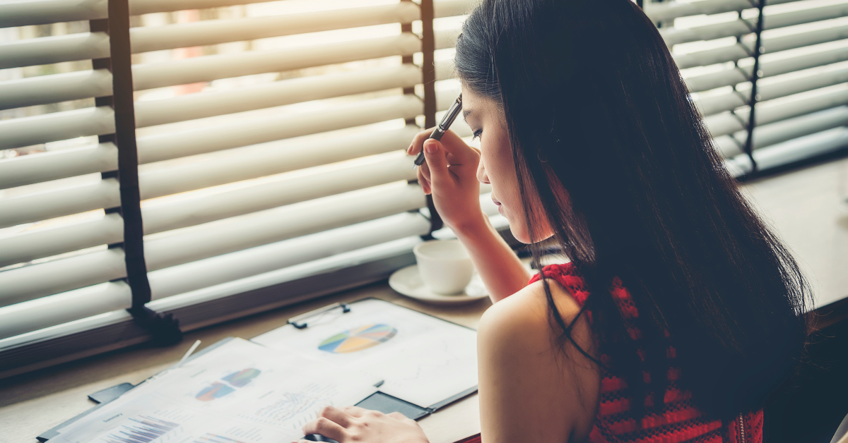 Woman reviewing financial reports and learning what's the difference between bookkeeping and accounting.