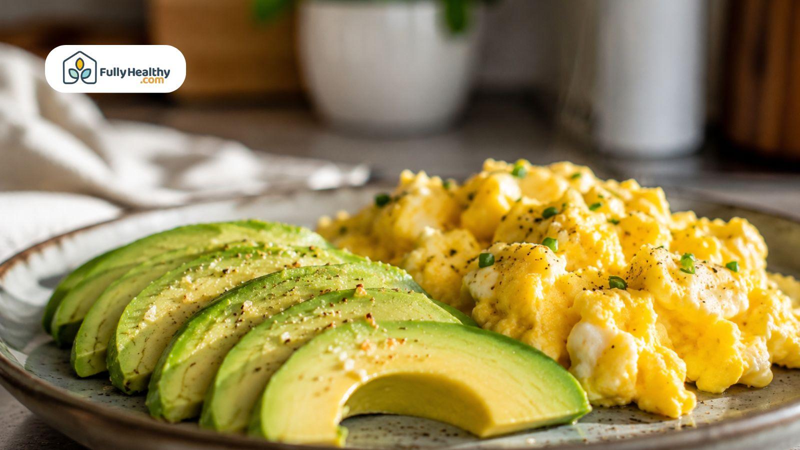 Creamy avocado slices with scrambled eggs on a ceramic plate in soft natural kitchen lighting.