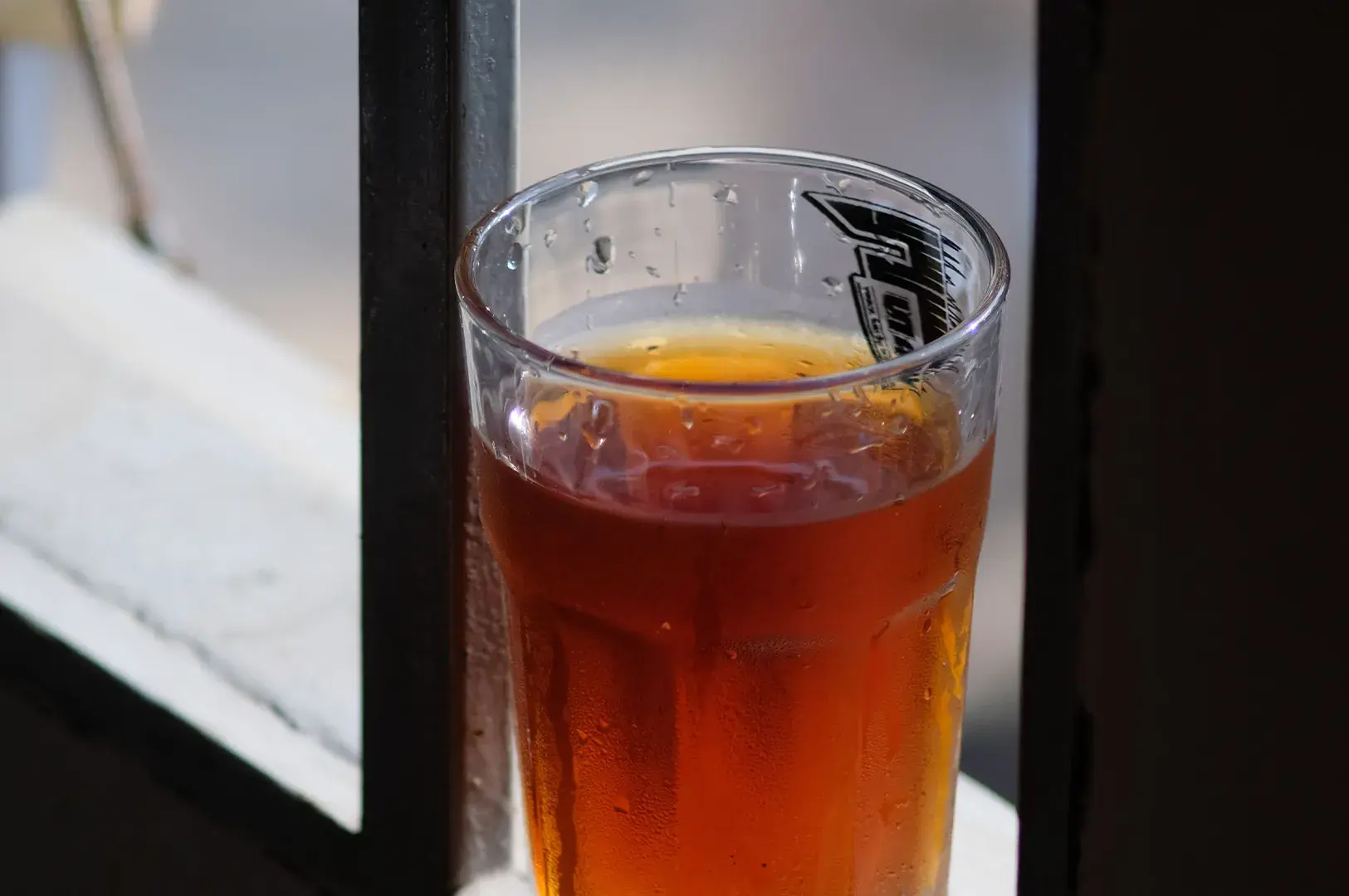 Clear glass filled with chilled amber tea.