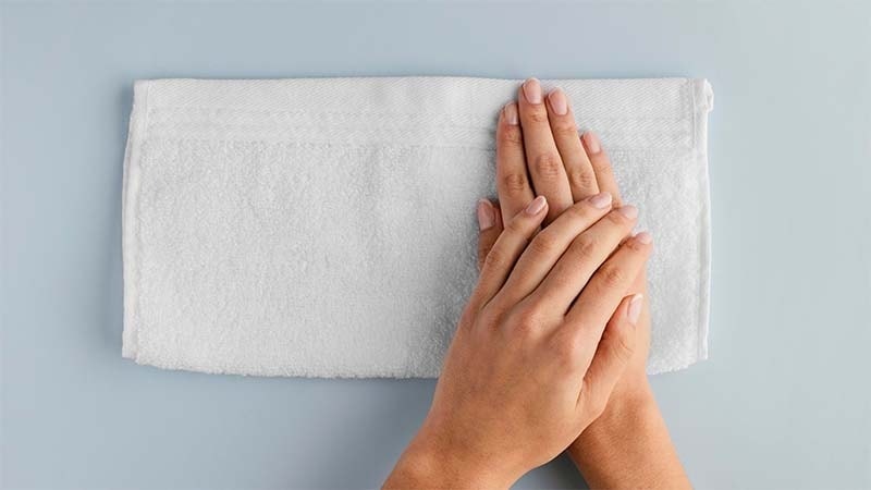Women drying their hands with a white towel
