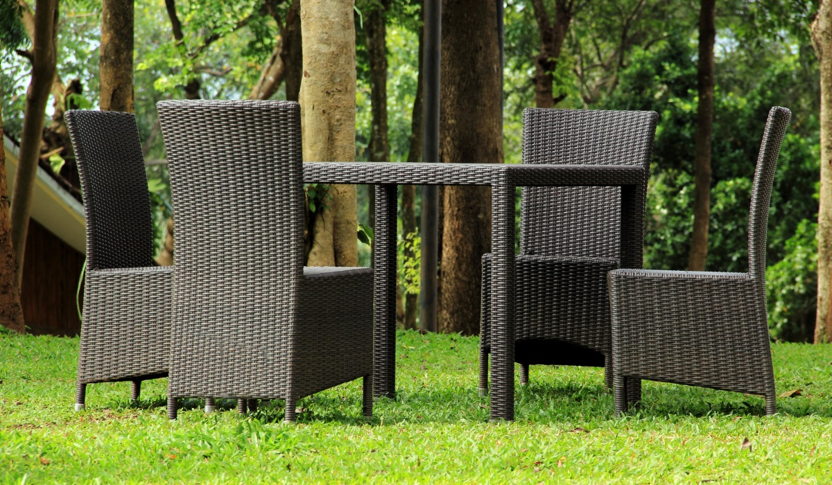 Rattan furniture - four high back chairs and dining table - very dark rattan - left outdoors on lawn 
