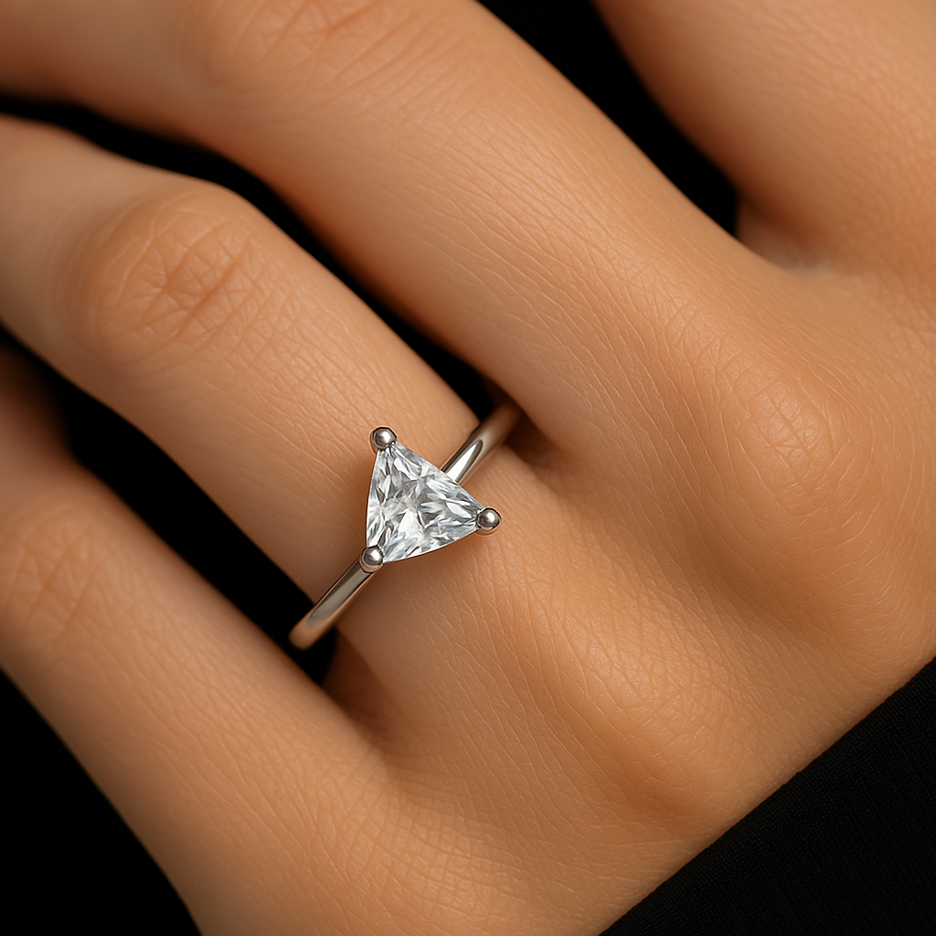 Sužadėtuvių žiedas iš 18k balto aukso klasikinio dizaino su centriniu trikampio formos deimantu ant stilingos merginos piršto.