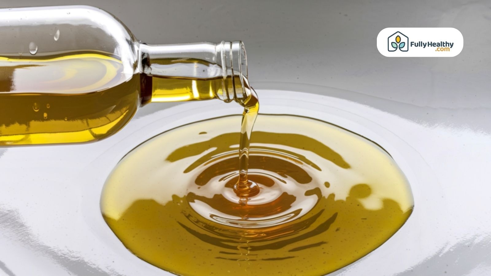 Extra virgin olive oil pouring from bottle into white surface