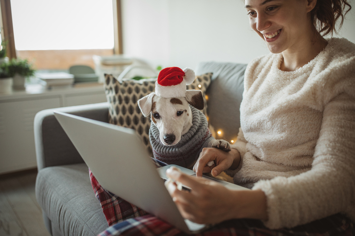 Cheerful young woman in pajamas shopping online. 