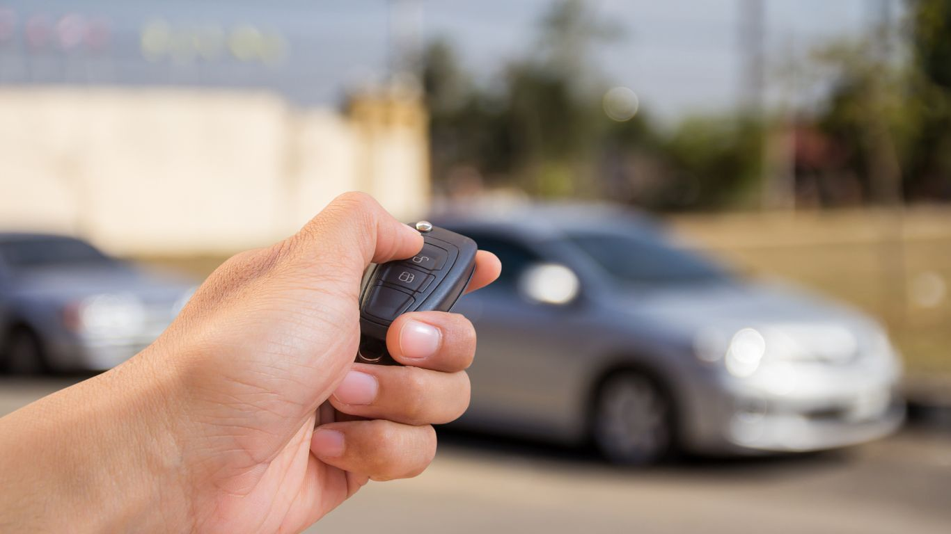 An image of a person holding a key fob that they programmed themself which is a great way to save on do it yourself car repairs