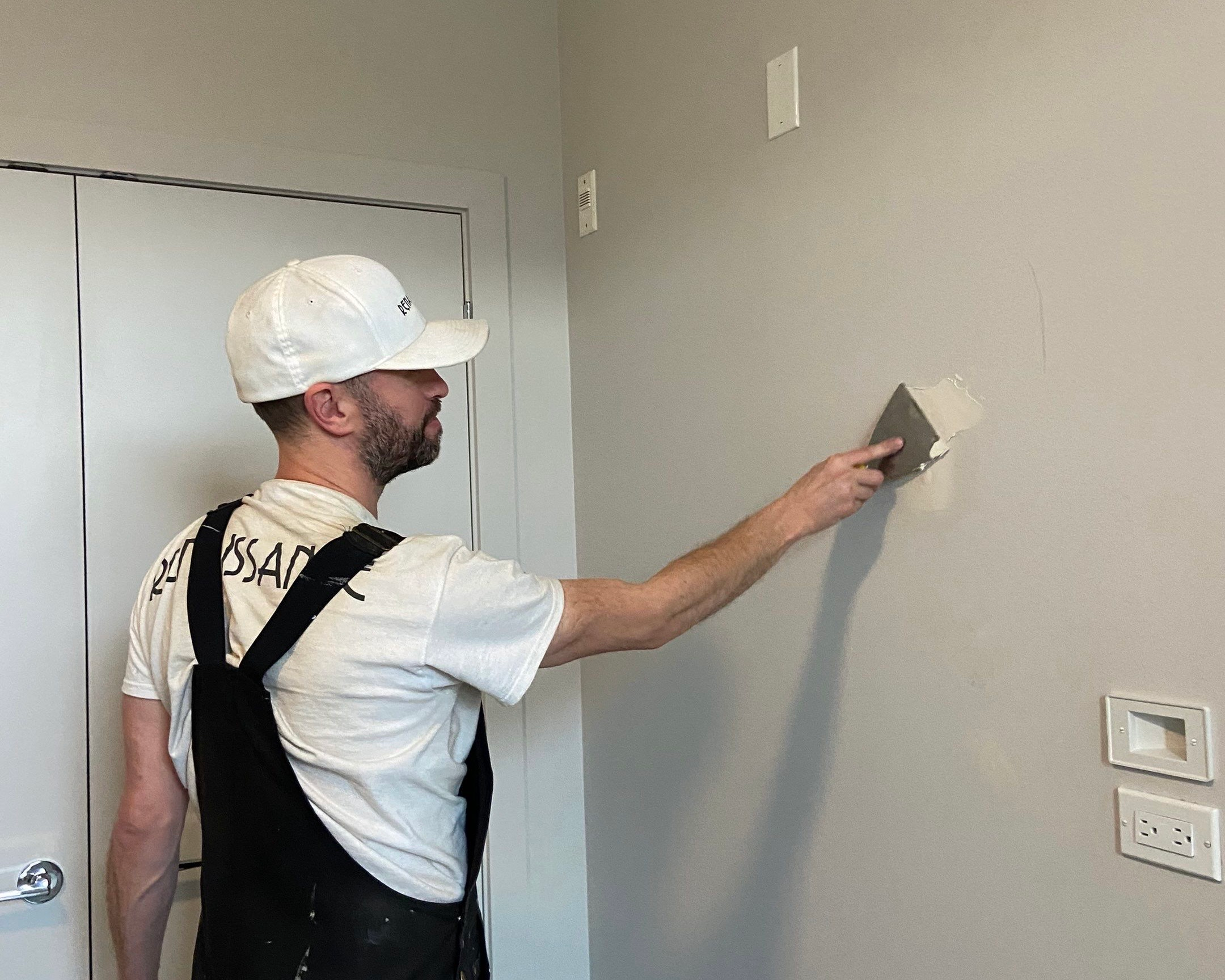 An image showing a professional painter preparing a wall surface for painting 