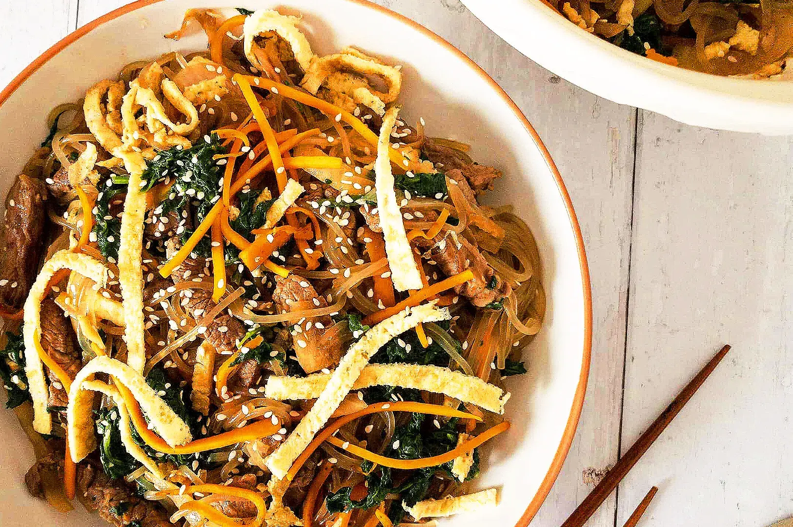 Korean japchae glass noodles with beef, vegetables, carrots, spinach and sesame seeds