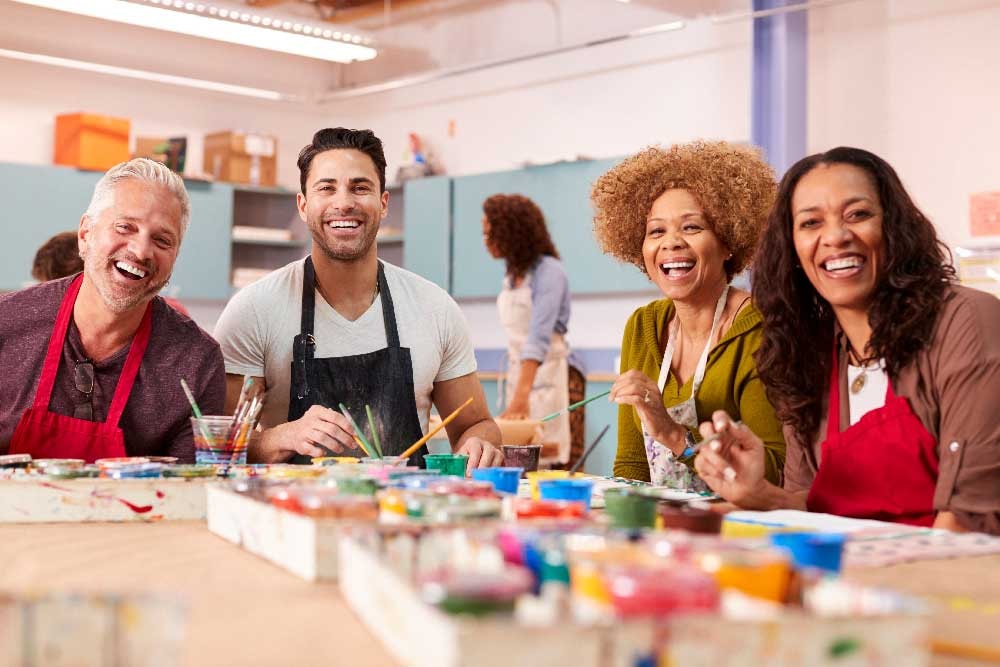 A group of adults enjoying a creative painting session together, showcasing how DIY art kits can bring joy and inspire self-expression.