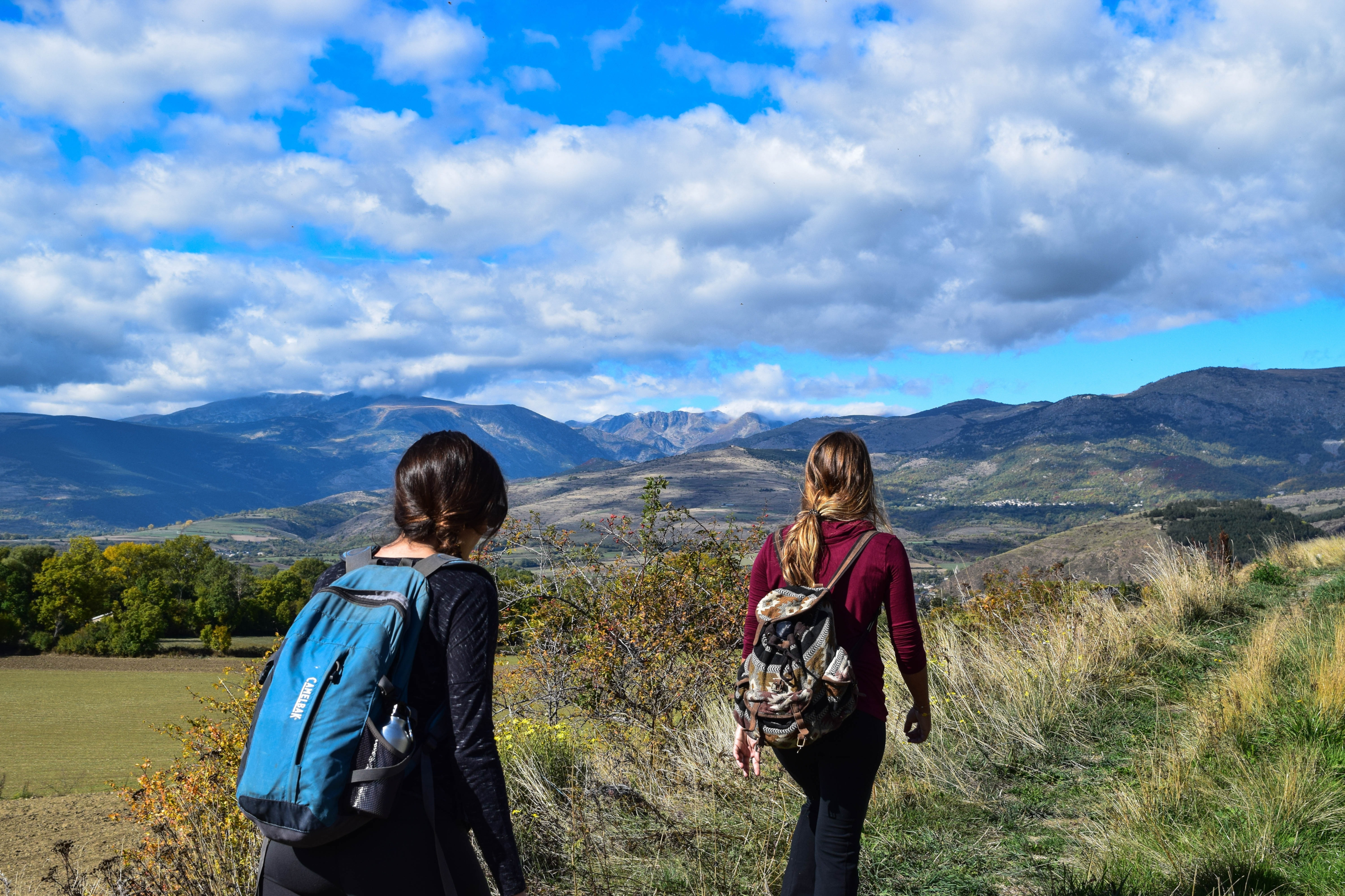 2 girls hiking with blue sky