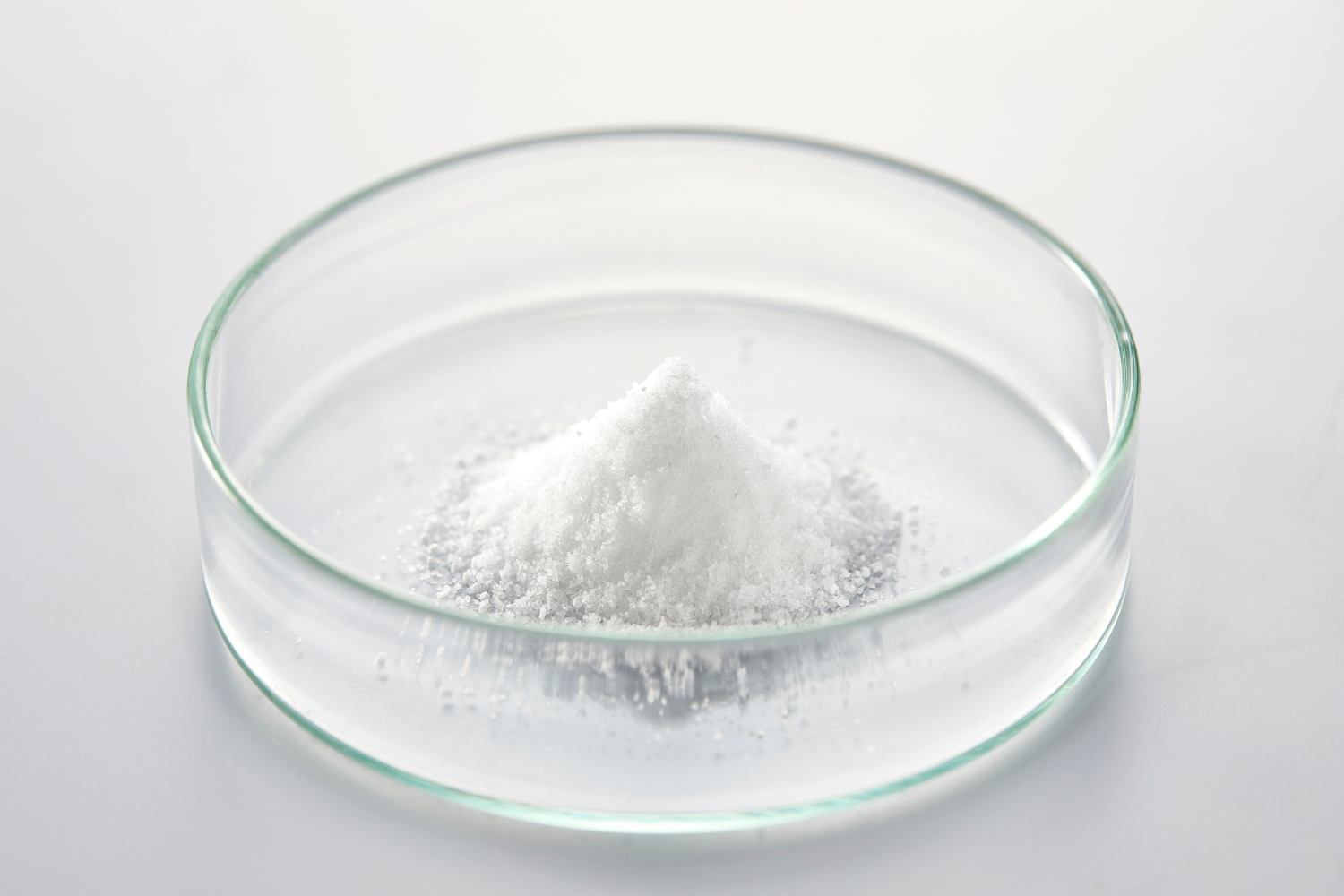 Powder in a glass bowl on a surface.